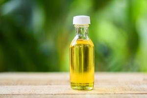 Sesam Öl im Glas Flaschen auf hölzern und Natur Grün foto