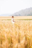 jung asiatisch Frauen im Weiß Kleider Gehen im das Gerste Reis Feld foto