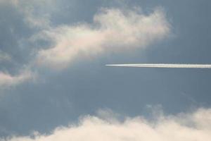 ein Flugzeug und Kondensstreifen am Himmel foto