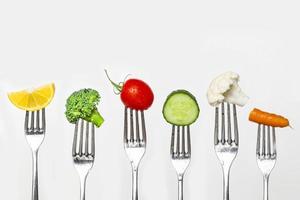 Obst und Gemüse von Silber Gabeln gegen ein Weiß Hintergrund Konzept zum gesund Essen, Diät und Antioxidans foto