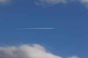 ein Flugzeug und Kondensstreifen am Himmel foto