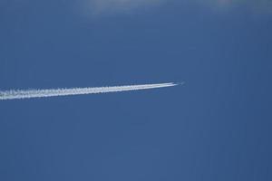 ein Flugzeug und Kondensstreifen am Himmel foto