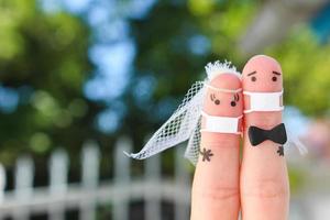 Finger Kunst von glücklich Paar im medizinisch Maske von covid-2019. Konzept von Hochzeit Zeremonie. foto