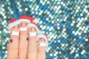 Finger Kunst von Familie im medizinisch Maske von covid-2019 feiert Weihnachten. Konzept von Menschen im Neu Jahr Hüte. foto
