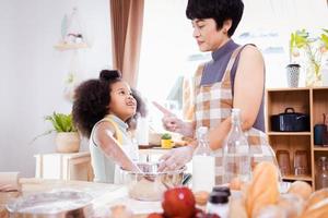 glücklich afrikanisch amerikanisch Familie genießen zusammen während bereiten das Mehl zum Herstellung Kekse beim Zuhause foto