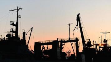 Silhouetten von Schiffen und Containerkränen im Seehafen foto