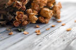 welk Bündel von Blumen, trocken Rosen auf hölzern Tabelle foto