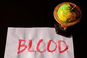Blut geschrieben auf Papier mit Globus foto