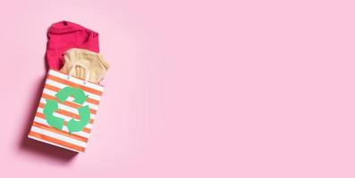 Kinder- Kleider im Einkaufen Tasche mit ein Recycling Symbol. zweite Hand, Spende Kleidung Recycling Konzept foto
