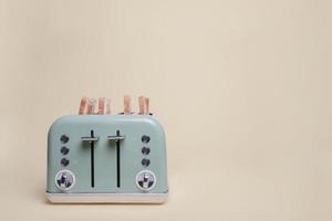 Retro grüner 4-Scheiben-Toaster auf einem Vintage-Bräunungshintergrund mit vier Scheiben Toast foto