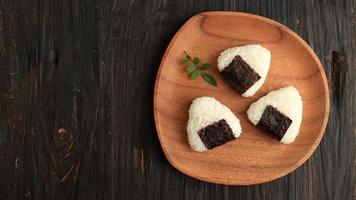 japanisch Dreieck Onigiri auf hölzern Teller foto