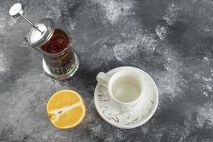 eine weiße Keramik Tasse Getränk mit einer Teekanne auf einem Marmorhintergrund foto