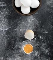 Schüssel mit weißen Eiern und Eigelb auf einem Marmorhintergrund foto