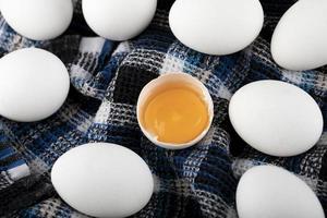 Eigelb und weiße Eier auf einem gestreiften Tuch foto