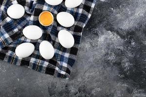 Eigelb und weiße Eier auf einem gestreiften Tuch foto