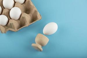 Behälter mit frischen Eiern auf blauem Hintergrund foto