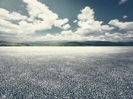 leeren Asphalt Pflaster mit Blau Himmel und Weiß Wolke Berg Hintergrund foto