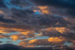 atemberaubend bunt Gewitterwolken im Blau Himmel, beleuchtet durch Strahlen von Sonne beim Sonnenuntergang zu Wetter ändern. abstrakt Meteorologie Hintergrund foto