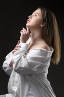 ein schön Mädchen im ein Weiß Hemd entblößt ihr Schulter. foto