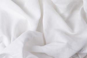 ein Fragment von zerknittert Weiß Stoff wie ein Hintergrund Textur.zerknittert Weiß Leinen- oder Baumwolle Stoff. foto