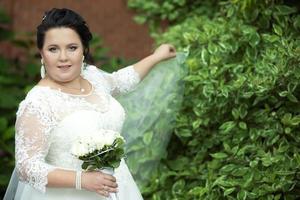 schön Fett Braut posieren im ein Weiß Hochzeit Kleid. foto