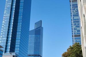 modern Stadt die Architektur, Wolkenkratzer Glas Fassade mit Grün Baum foto