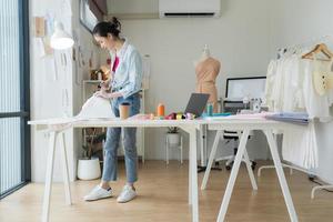 weiblich Unternehmer sind Herstellung Neu Kleidung Sammlungen. foto
