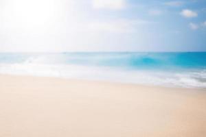 verschwommen Strand Hintergrund mit Sonnenstrahlen, Sommer- sandig leeren Strand foto