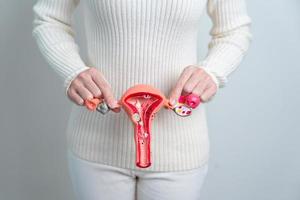 frau, die gebärmutter- und eierstockmodell hält. Eierstock- und Gebärmutterhalskrebs, Gebärmutterhalskrebs, Endometriose, Hysterektomie, Uterusmyome, Fortpflanzungssystem und Schwangerschaftskonzept foto