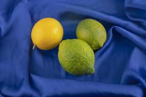gelbe und grüne Zitronen auf einer blauen Tischdecke foto
