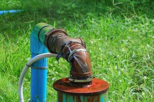 Installation Main Tube und Wasser Leck, alt Zapfhahn Rohr Stahl Rost auf Gras Fußboden foto