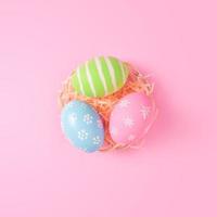 glücklich Ostern Urlaub Gruß Karte Konzept. bunt Ostern Eier auf Pastell- Rosa Hintergrund. eben legen, oben Sicht, Kopieren Raum. foto
