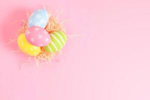 glücklich Ostern Urlaub Gruß Karte Konzept. bunt Ostern Eier auf Pastell- Rosa Hintergrund. eben legen, oben Sicht, Kopieren Raum. foto