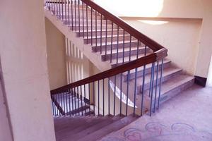 Rangpur, Bangladesch. Februar 18, 2020. Treppe mit Holz Geländer.Treppe im ein modern Hochschule Universität Gebäude.Luxus Benutzerdefiniert gebaut Zuhause Innere. Weiß Wände und ein treppe.spirale Treppe foto