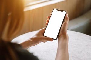 Frau mit digitalem Tablet und Smartphone mit leerem weißen Desktop-Bildschirm im Café foto