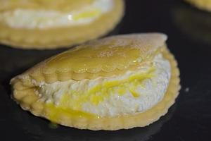Kekse mit Hütte Käse auf ein Backen Blatt verschmiert mit Ei Eigelb. foto