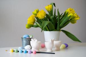 Ostern Banner mit süß Hase geformt Ei Inhaber im Pastell- Farben in der Nähe von Tulpen. Farbe eier.zubereiten zum Urlaub foto