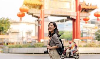 jung asiatisch Frau Rucksack Reisender genießen China Stadt, Dorf Straße Essen Markt im Bangkok, Thailand. Reisender Überprüfung aus Seite Straßen. foto