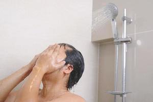 ein Mann ist mit Dusche Sahne zum trocken Haut kehrt zurück Haut zu Sein weich, befeuchtet und genährt foto