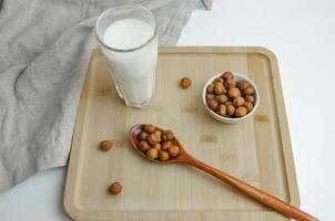 auf ein hölzern Tafel Haselnuss Nüsse und ein Glas von Milch, das Konzept von Milch von Nüsse foto