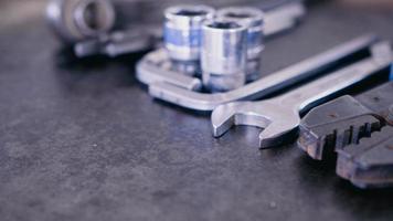 Hand Werkzeuge bestehend aus von Schraubenschlüssel, Zange, Steckdose Schraubenschlüssel, gelegt aus auf alt Stahl Teller Hintergrund. foto