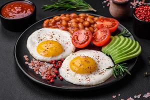 köstlich nahrhaft Englisch Frühstück mit gebraten Eier, Tomaten und Avocado foto