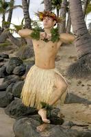 männlich Hula Tänzer posiert im Vorderseite von Palme Bäume auf das Strand foto