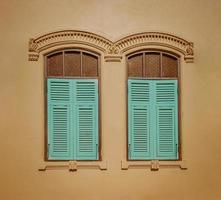 Jahrgang Fenster mit Blau Fensterläden auf Gelb Mauer Hintergrund. retro Stil. foto