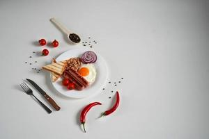 Englisch Frühstück - - gebraten Ei, Tomaten und Würstchen auf Weiß Hintergrund. oben Sicht. Kopieren Raum zum Text foto