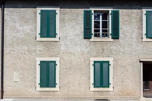 Fassade eines Steinhauses mit grünen Fensterläden foto