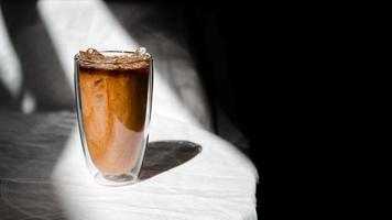 Glas Eiskaffee mit Milch auf dem Tisch foto