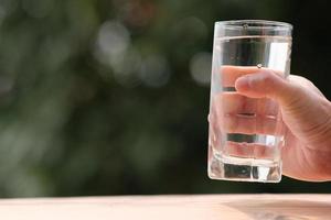 mineralisches Trinkwasser auf Holztisch und Wasser in Glas foto