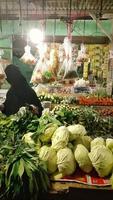 bogor Indonesien März 2023 ein Frau ist Einkaufen zum Gemüse beim ein Gemüse Geschäft foto