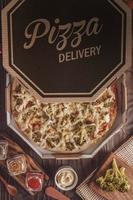 Pizza mit Mozzarella, Brokkoli, Catupiry und Parmesan in einer Lieferbox foto